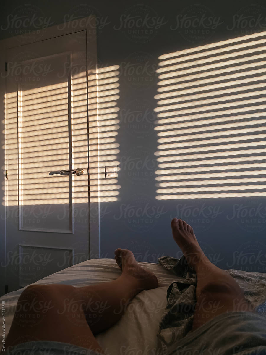 legs of anonymous Man lying down sleeping on bed in the morning