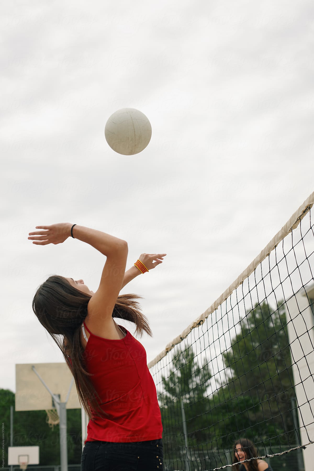 Young girl playing volleyball at school