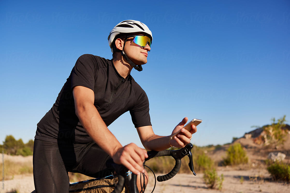 Male cyclist using smartphone on bike