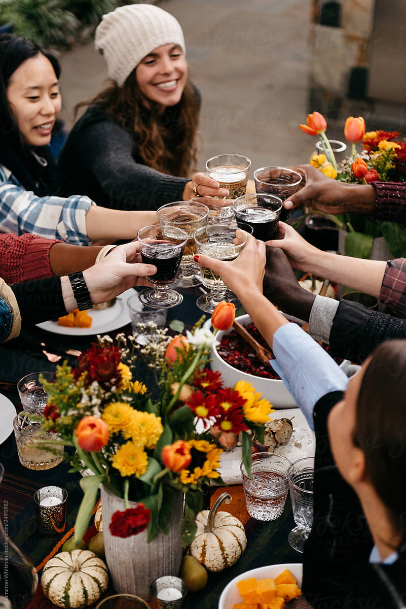 Friends toasting over a fall outdoor dinner table