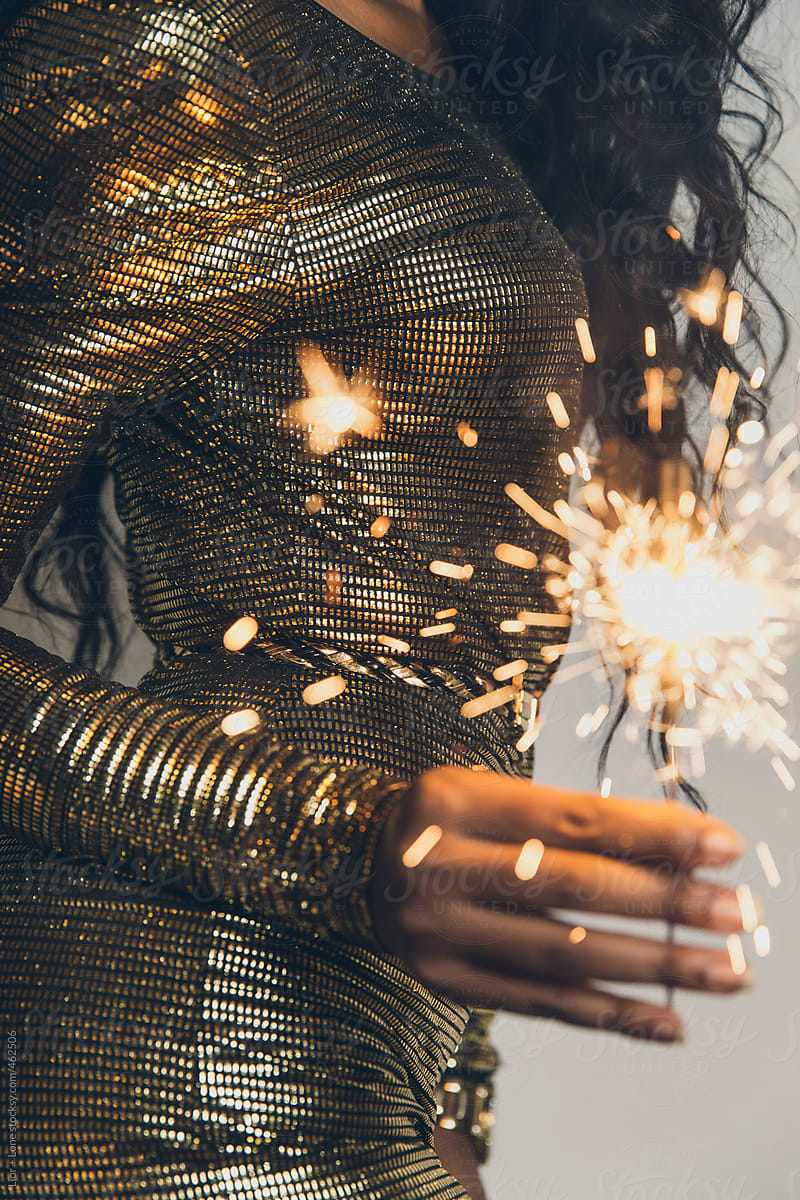 Black Woman In Golden Dress Dancing With A Sparkler In Her Hand" by Stocksy  Contributor "Lior + Lone" - Stocksy