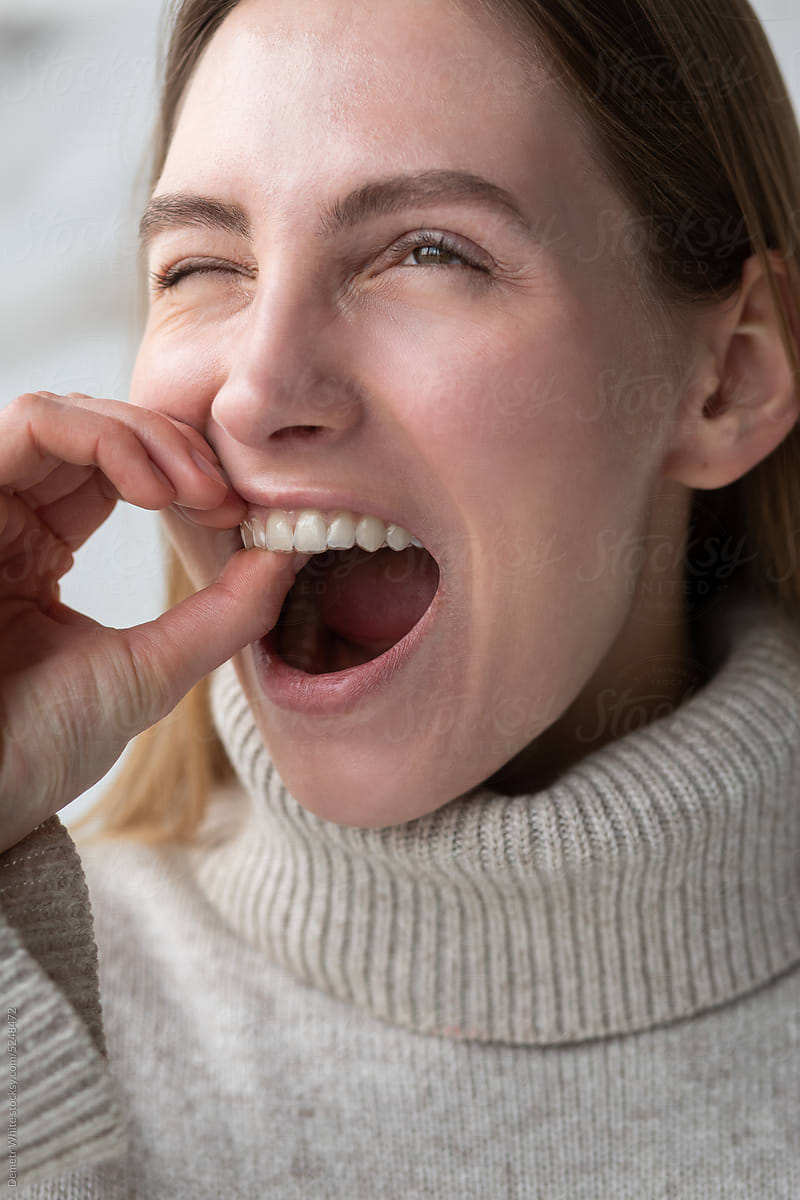 White woman trying to remove a transparent dental aligner