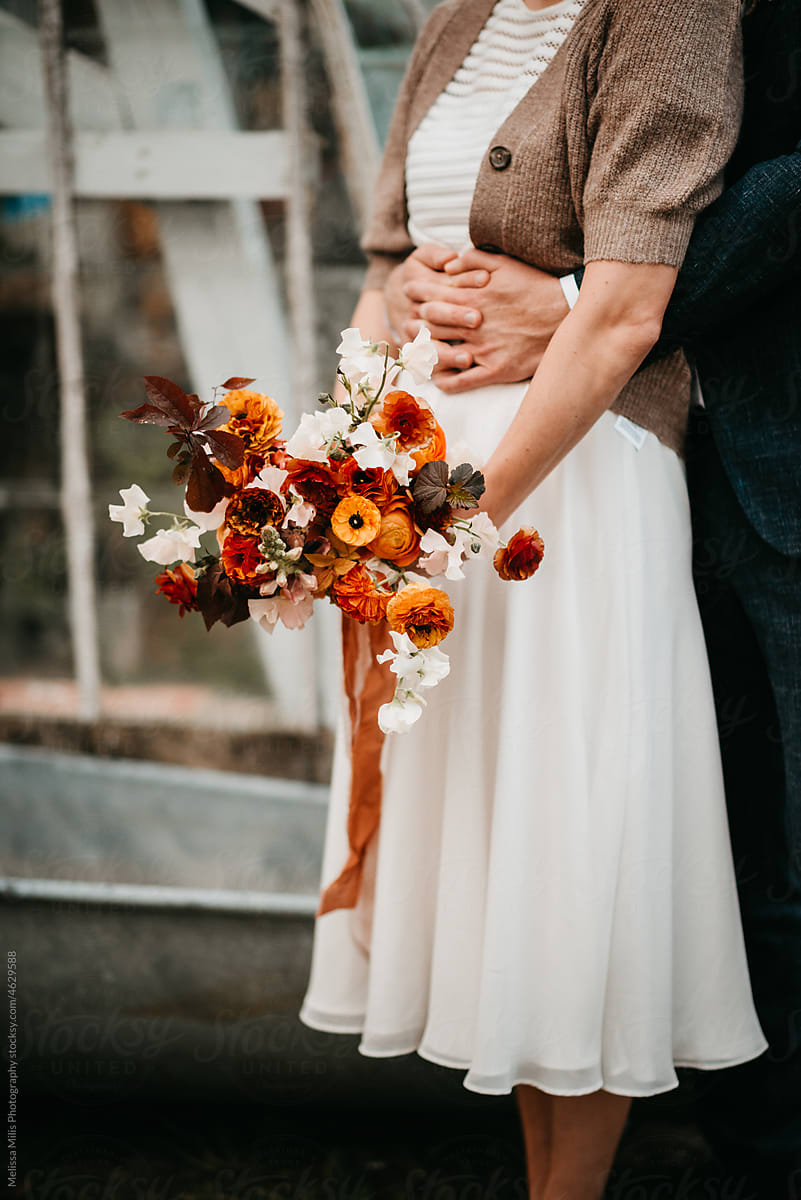 Anonymous portrait of wedding couple with autumn wedding bouquet