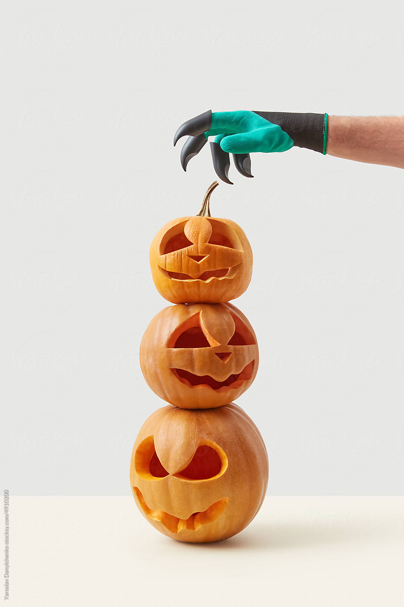 Halloween pumpkins and hand in costume glove.