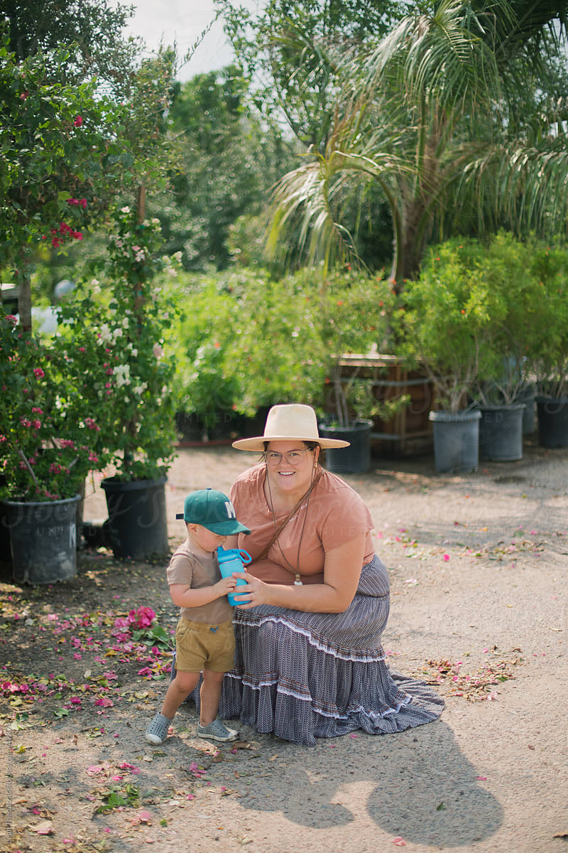 Mother Giving Toddler Water while at Plant Nursery