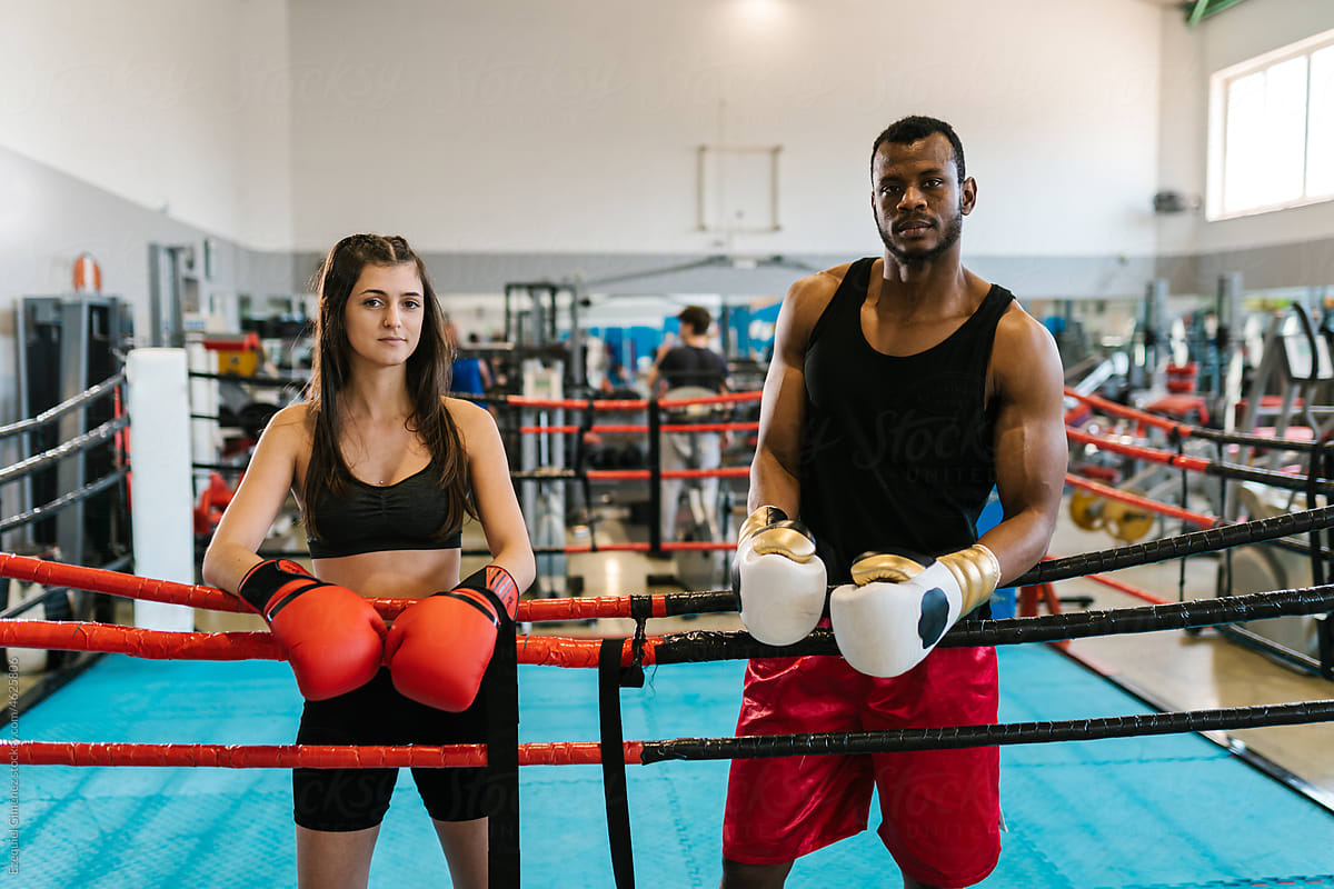 Calm diverse male and female boxers standing in ring