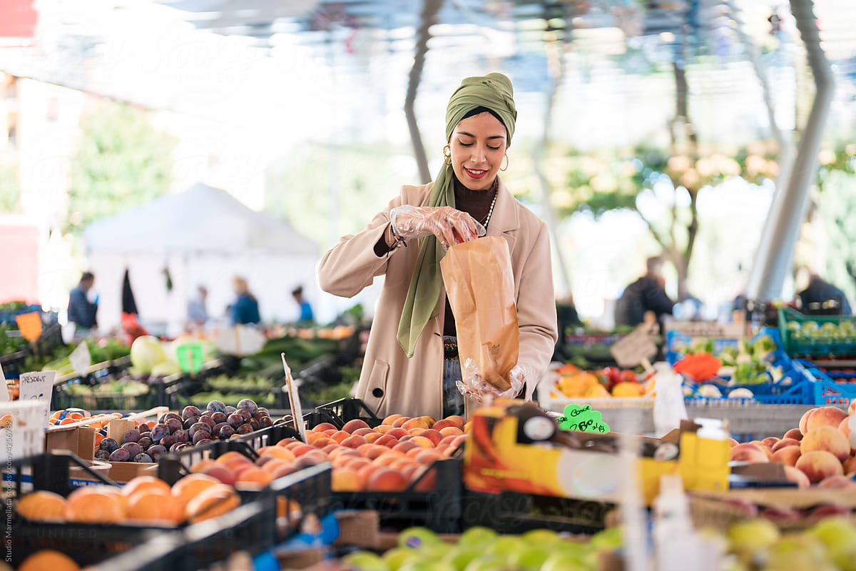 Muslim female packing fruits on market