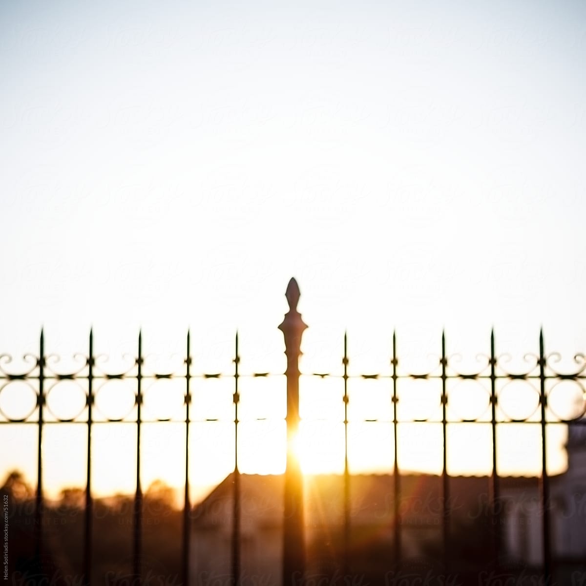 A fence that is backlit by the sun