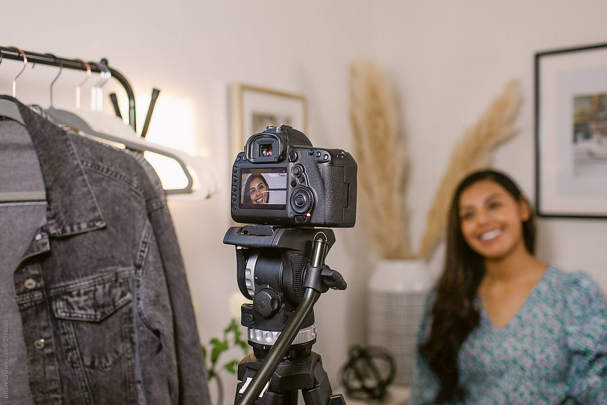 Smiling Hispanic woman recording video for social media blog