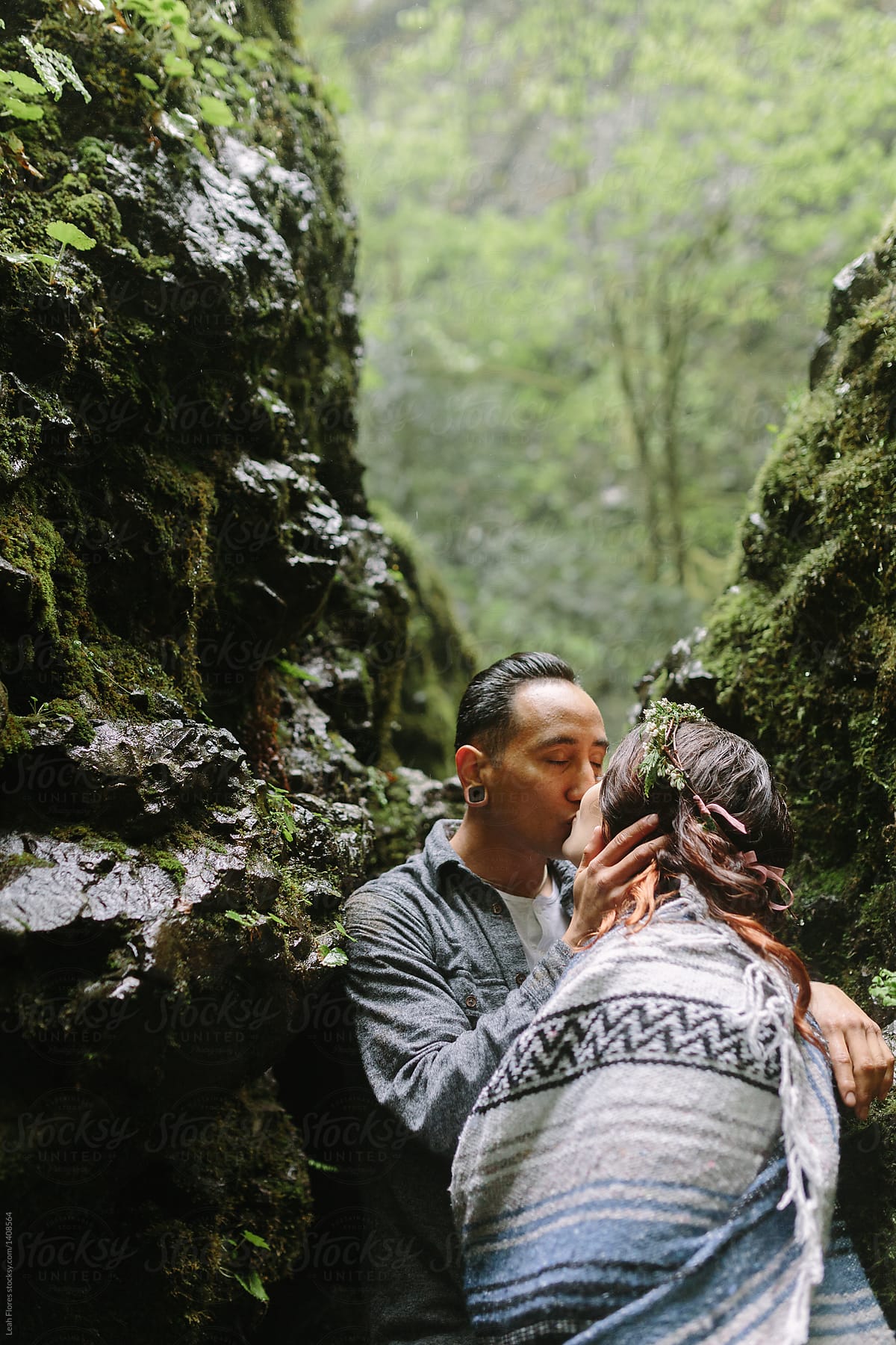 Couple Kissing by Mossy Rocks in the Rain