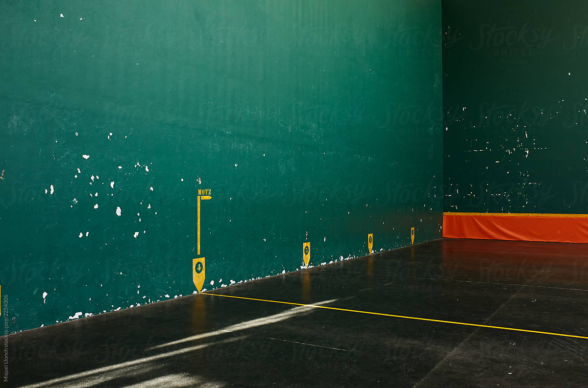 Basque pelota court corner with green walls and nobody.