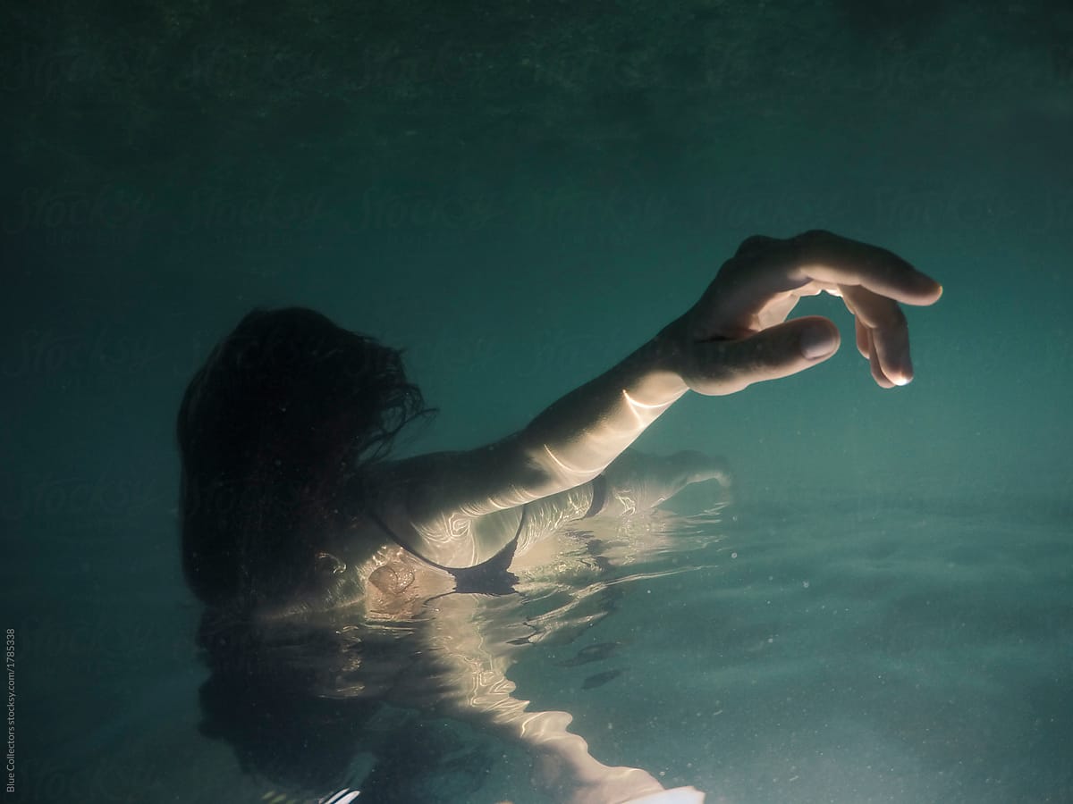 Peaceful woman floating in the water from underwater view