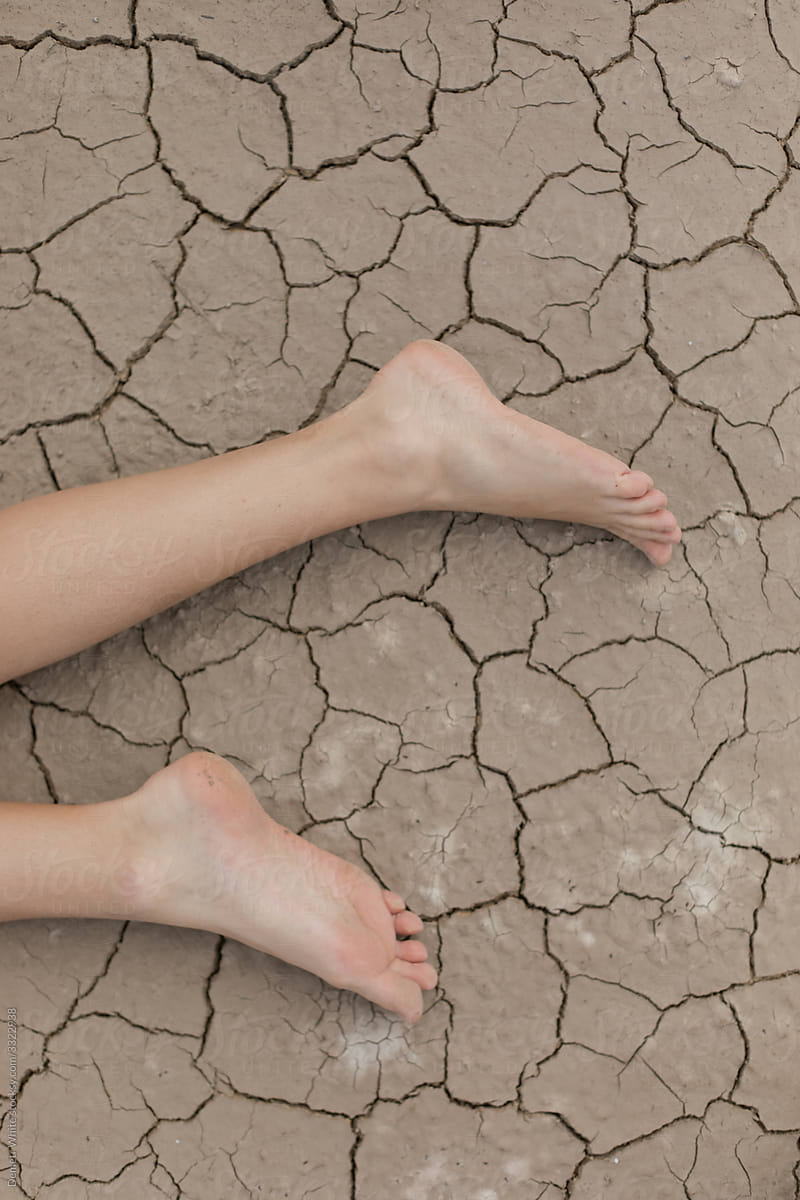 human feet on the background of cracked earth
