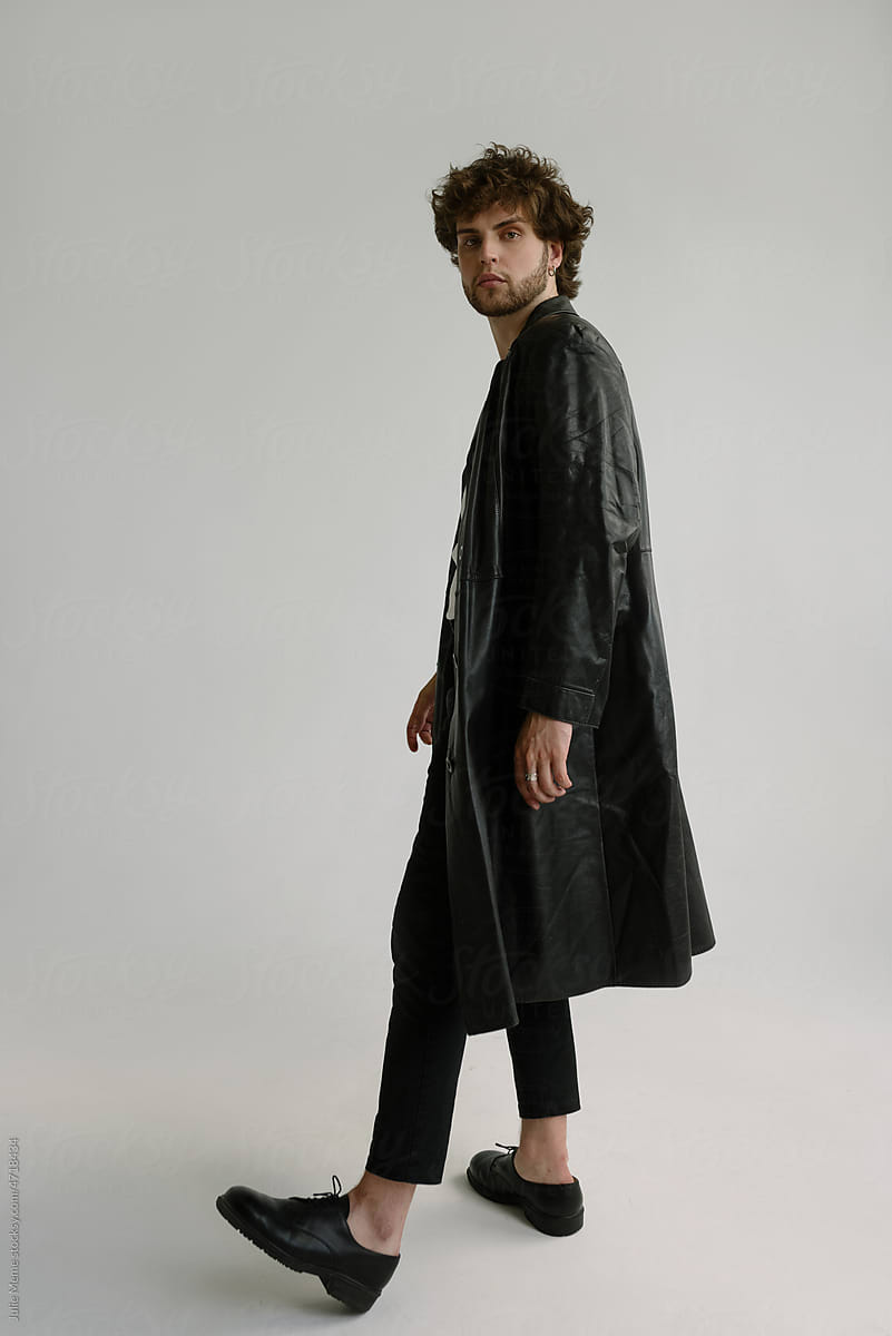 Attractive curly man in a black leather jacket and shoes