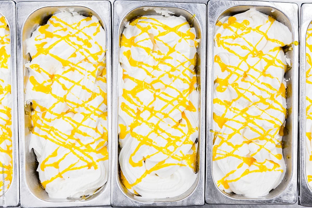 Vanilla ice cream with yellow sauce in commercial containers
