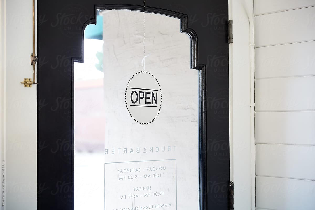 Open sign on front door of small business of artisan retail store