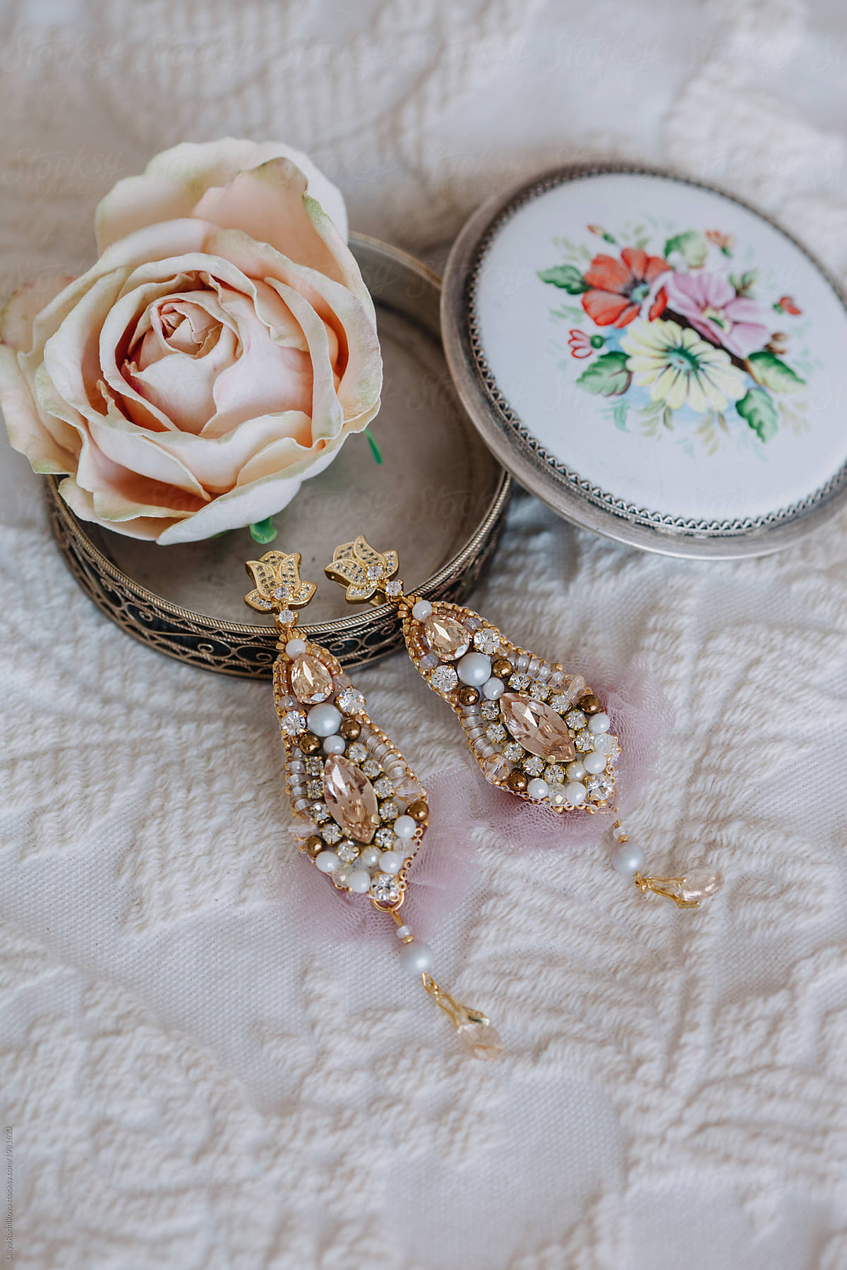 Closeup shot of beautiful earrings, rose and box for jewels