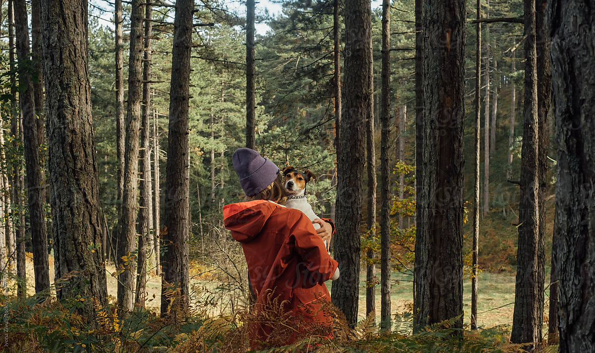 Woman Hiker Carrying Her Dog in Forest