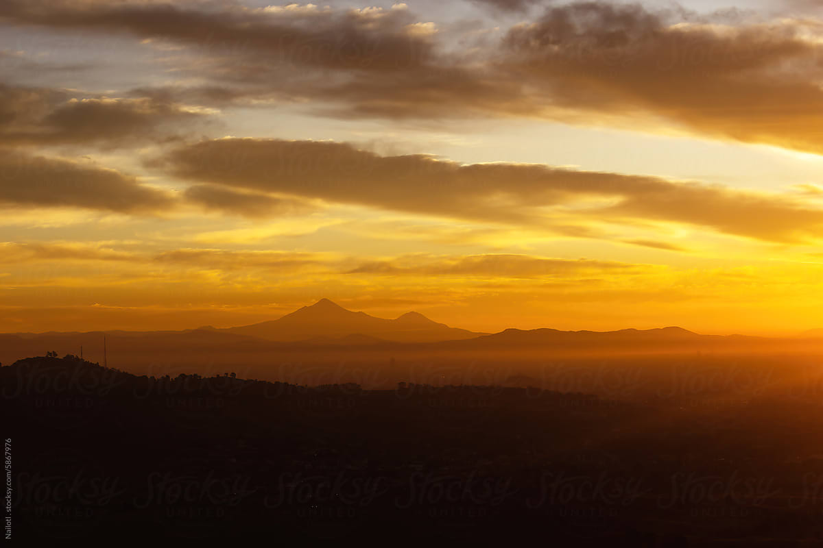 Pico de Orizaba volcano and Sierra Negra on the city skyline at dawn.