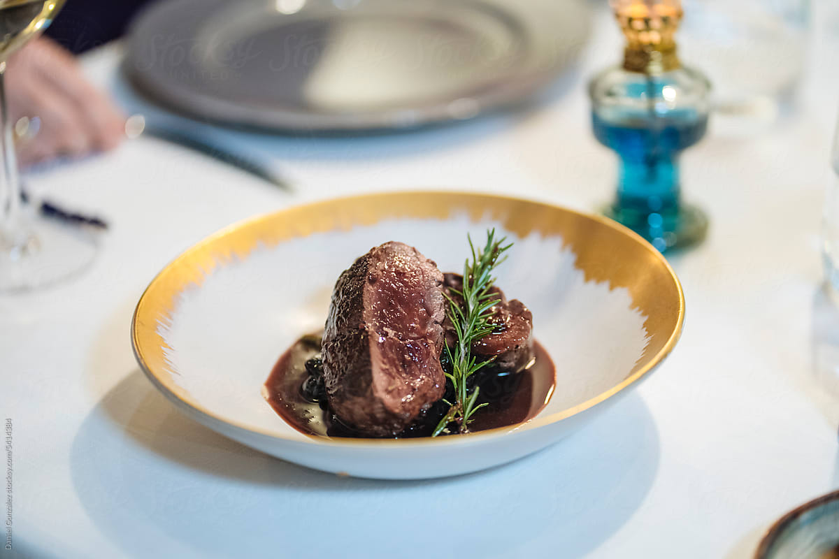 Appetizing steak with rosemary on plate in restaurant