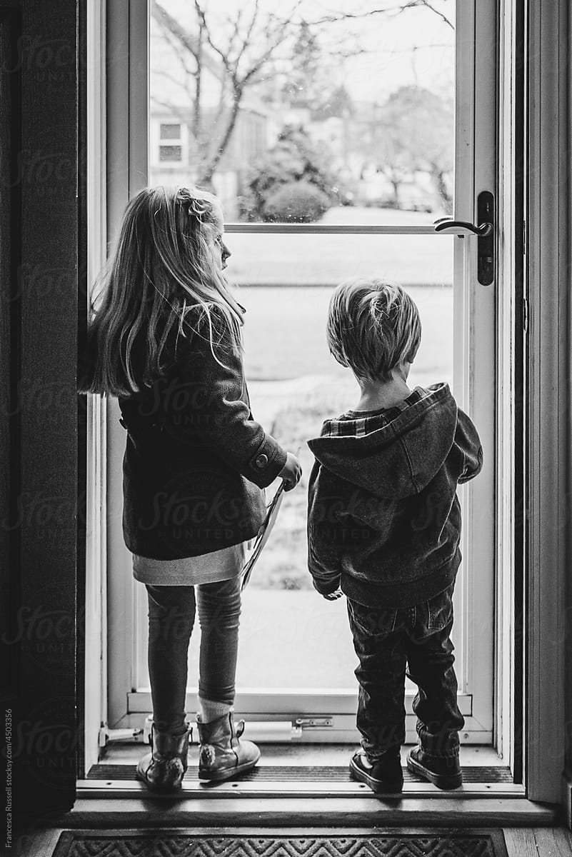 Two children standing at front door