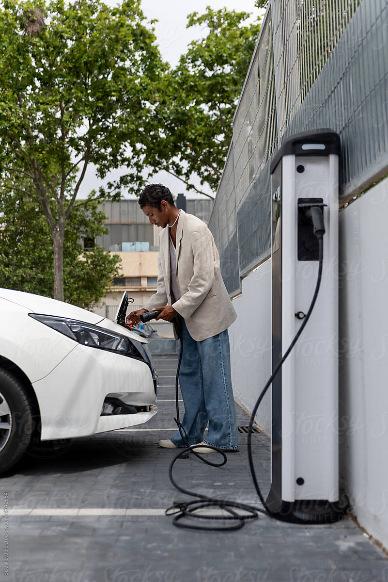 Black man charging an electric car