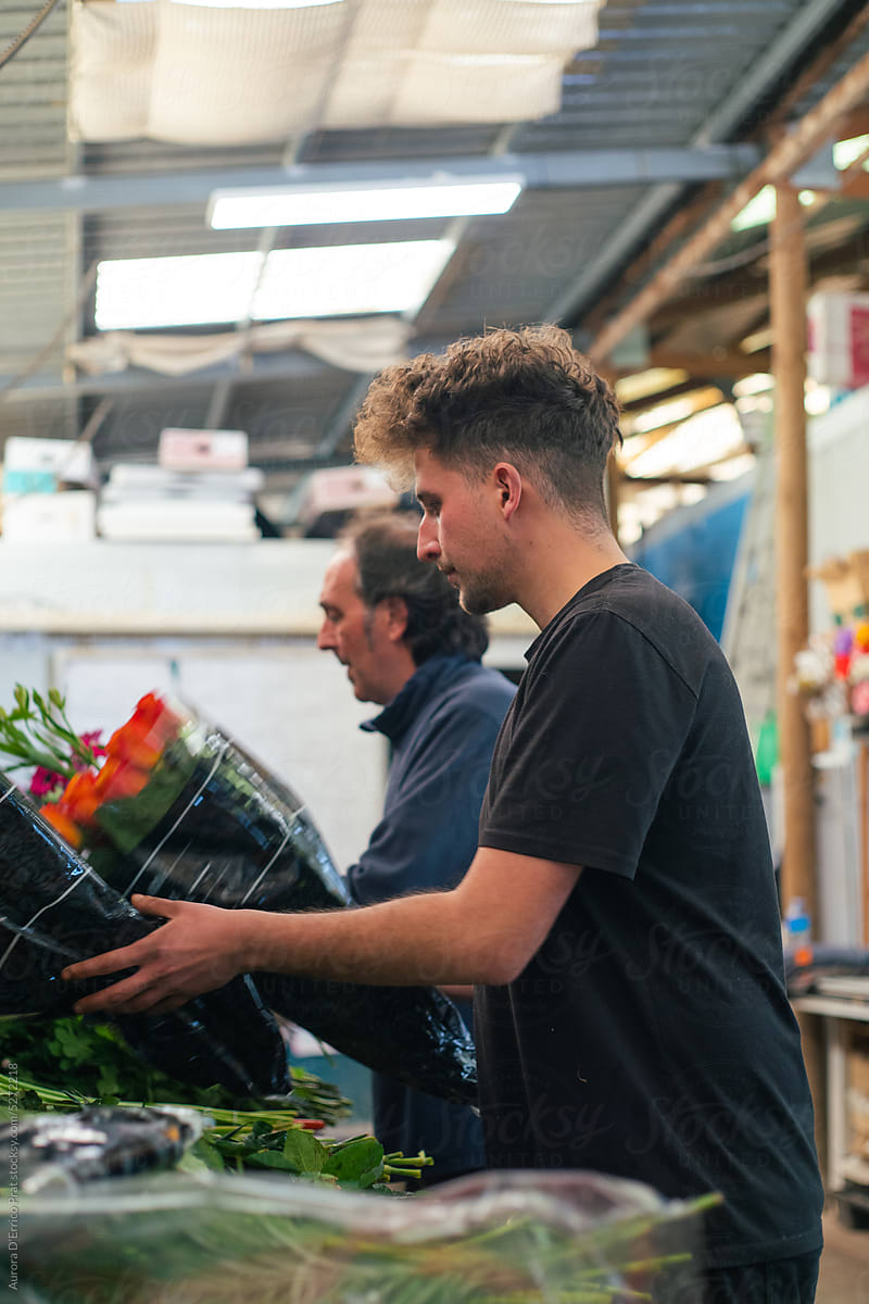 Two men assembling a bouquet of flowers
