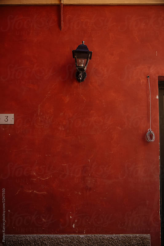 Red building wall with old lamp