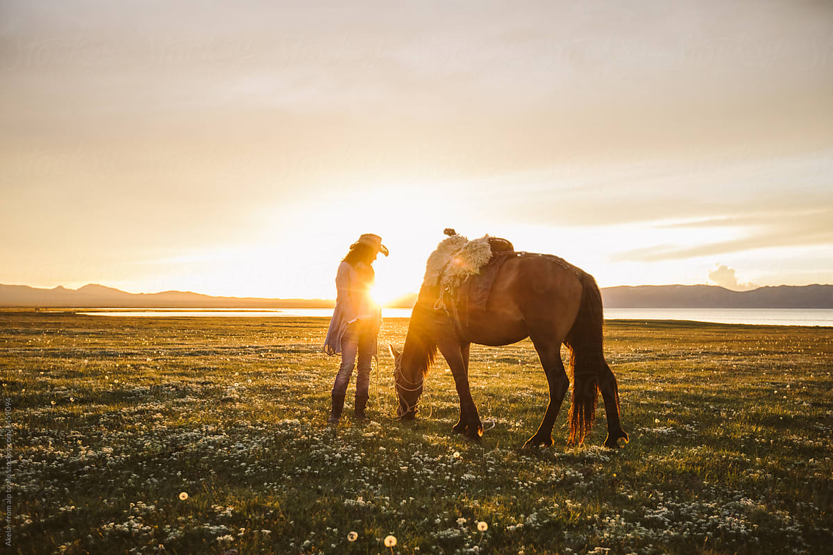 cowgirl and her horse at sunset