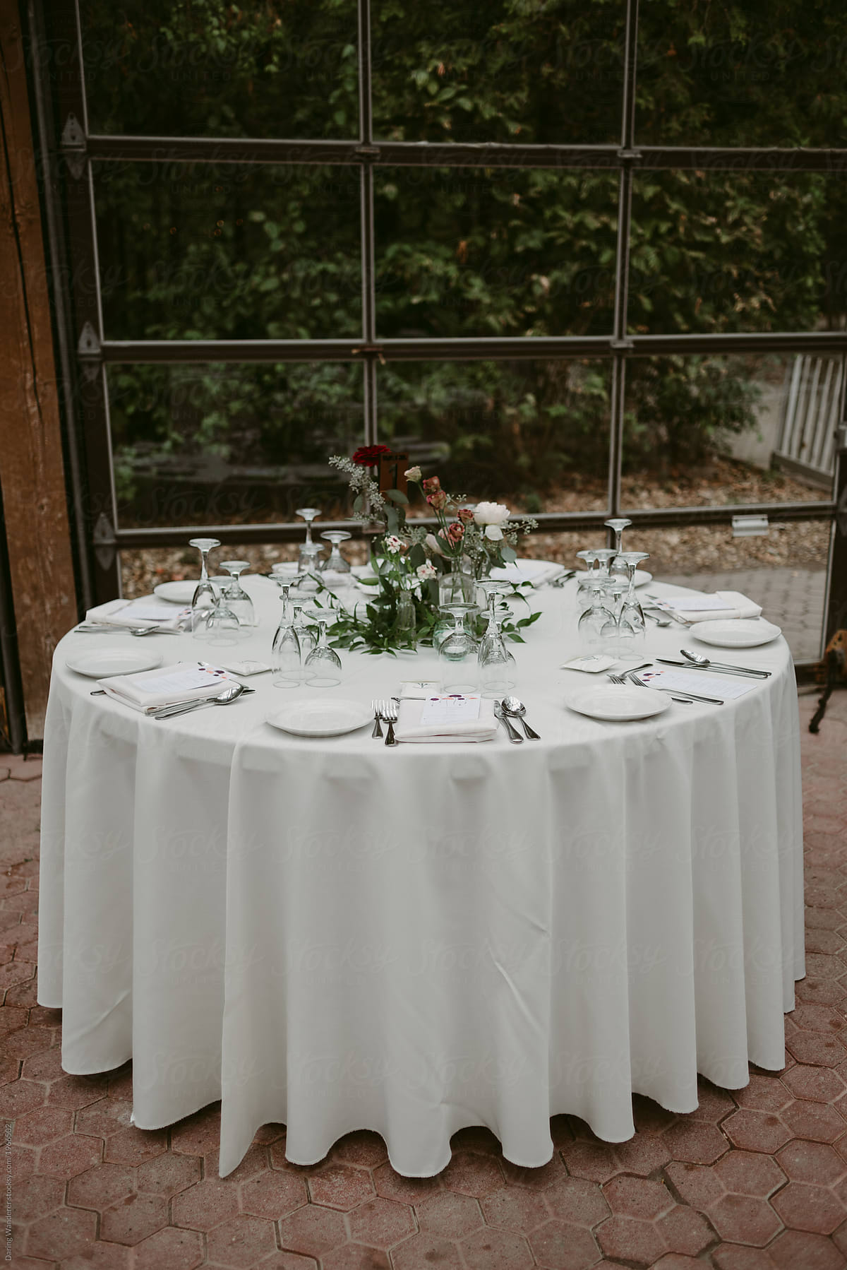 Round Table Set Up For Dinner In Glass Room By Jess Craven
