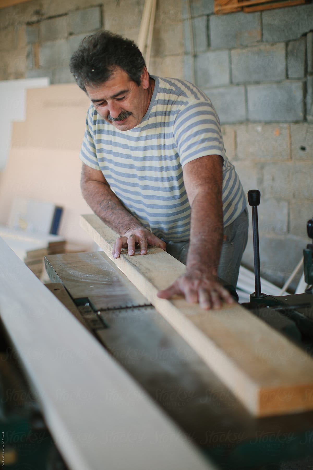 Carpenter Sawing a Board
