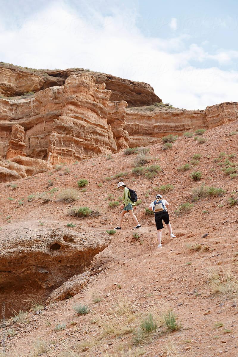 Hikers climbing slope of canyon