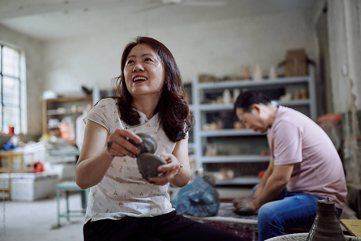 East Asian Small Business Owner Laughs While  In Her Pottery Workshop