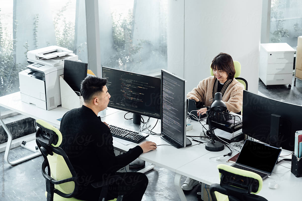 Casual business people working on computers in open plan office