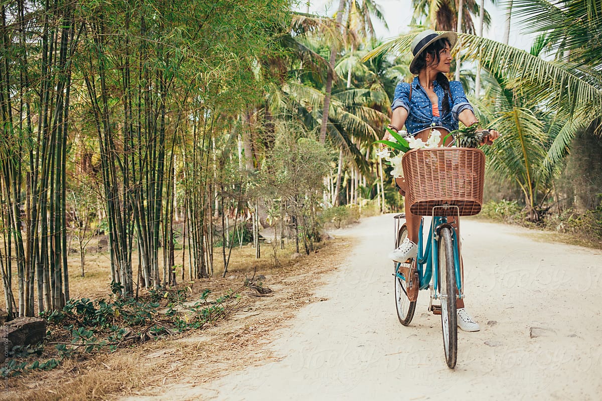 Happy Woman Riding a Bike in a Tropical Setting