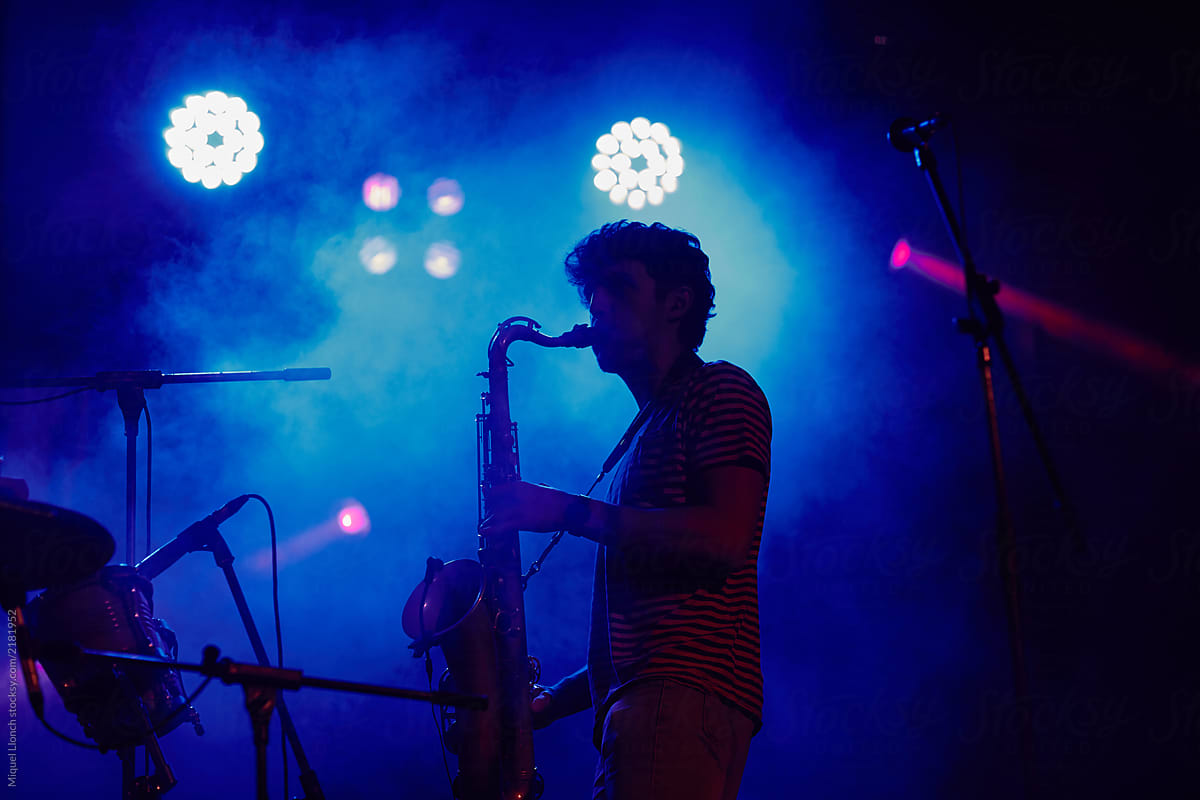 Silhouette of a musician playing the saxophone in a live concert