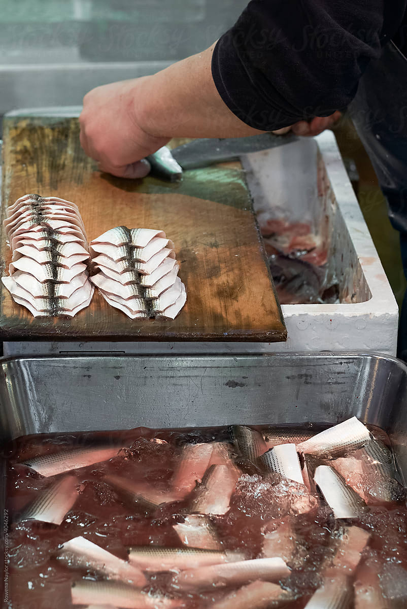 trader filleting fish at Tsukiji Market, Tokyo Fish Market