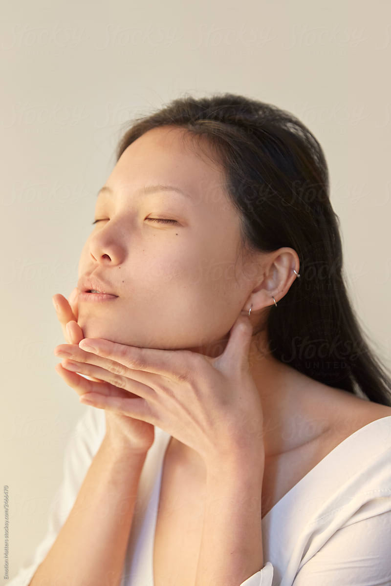 A woman demonstrating a jaw massage