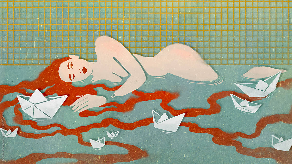A girl with long red hair lies in the pool.