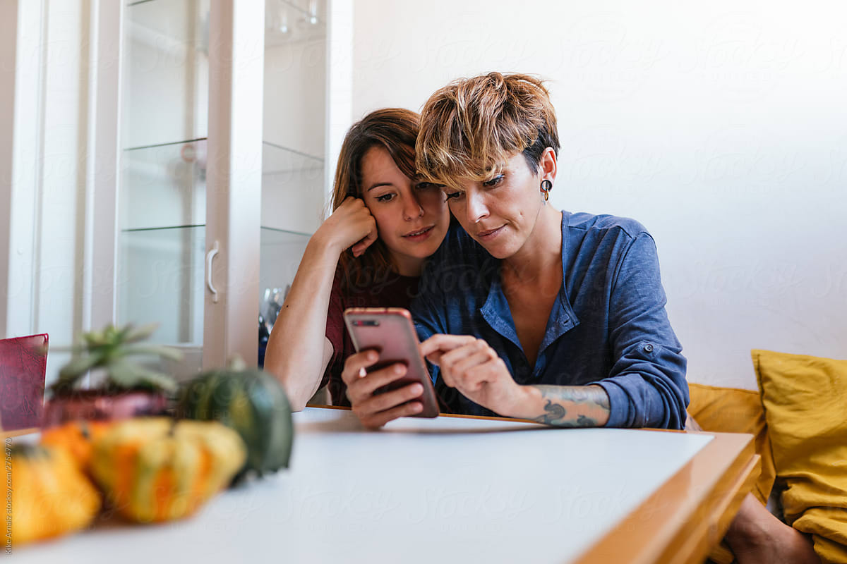 Lesbian Couple Using Phone By Stocksy Contributor Kike Arnaiz Stocksy 4888