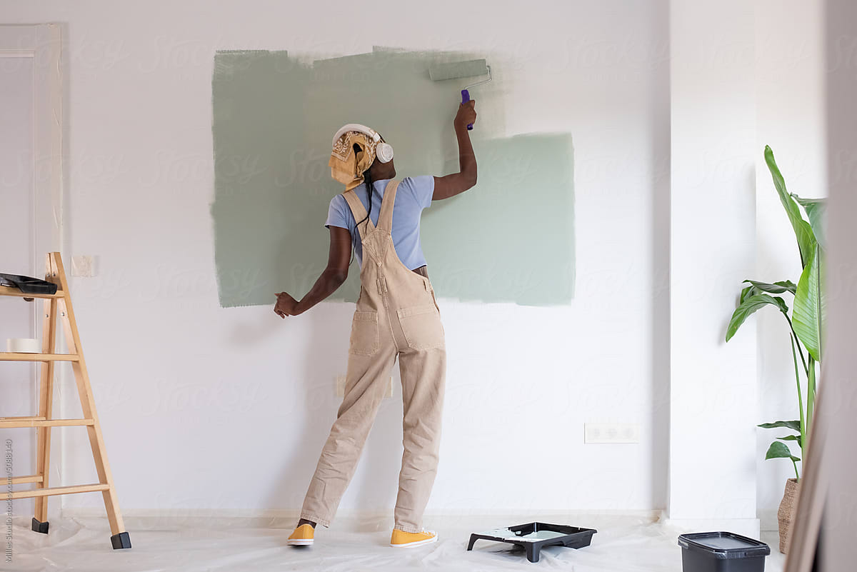 Woman dancing and smearing paint on wall