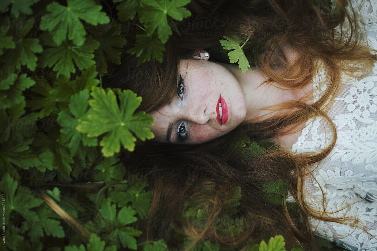 Beautiful Young Woman Lying In Grass And Looking At Camera Del Colaborador De Stocksy Jovana
