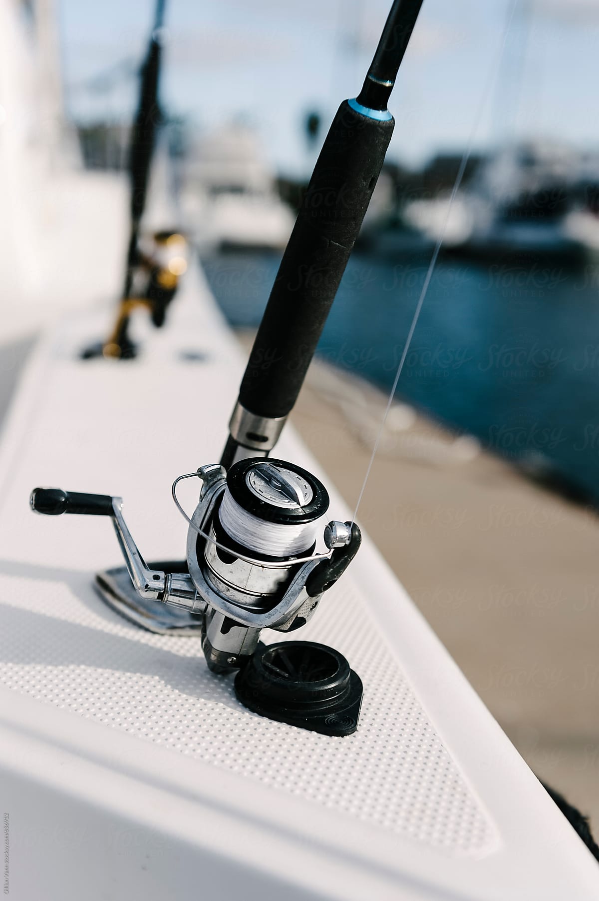 fishing rod and reel resting in rod hole on a luxury powerboat
