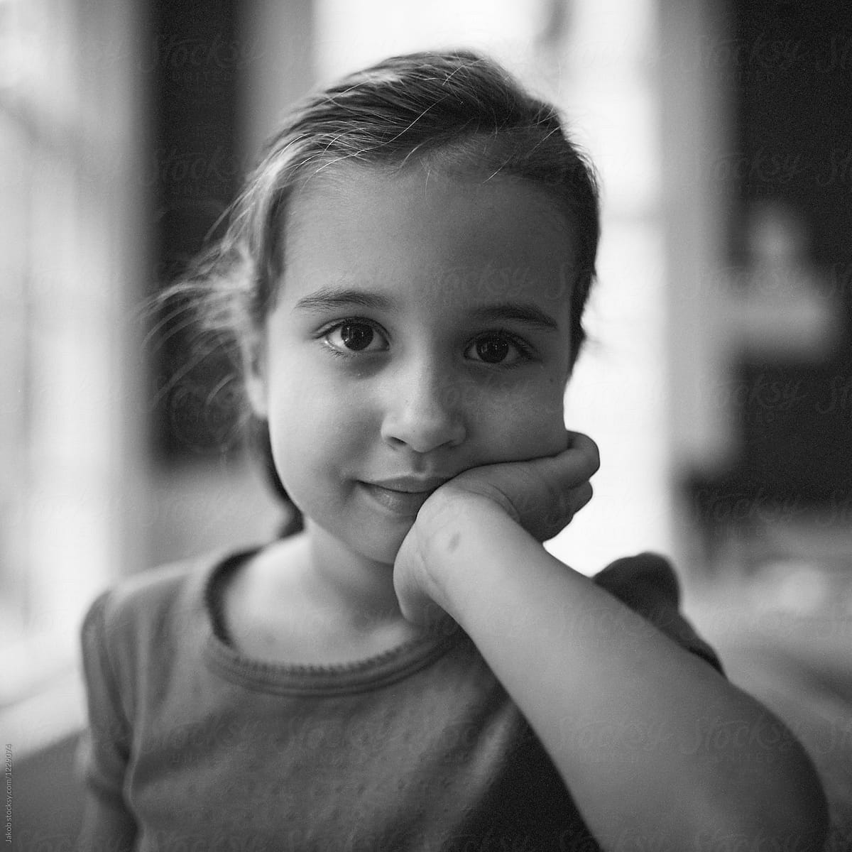 Black And White Portrait Of A Beautiful Young Girl Resting Her Head On Her Hand By Stocksy