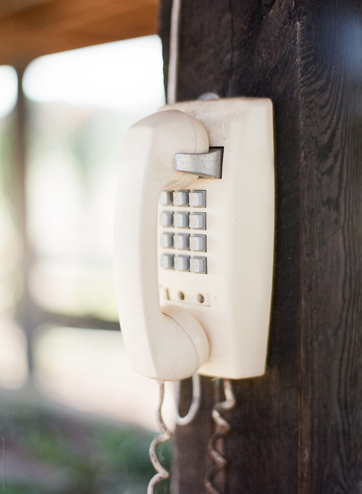 Old white wall telephone hanging outdoors