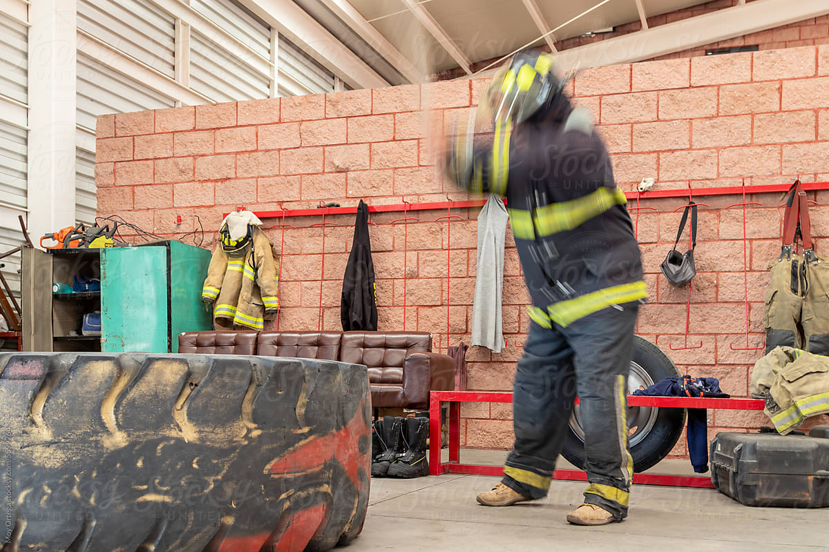 Motion Blurred Shot Of A Firefighter Training With His Uniform On.