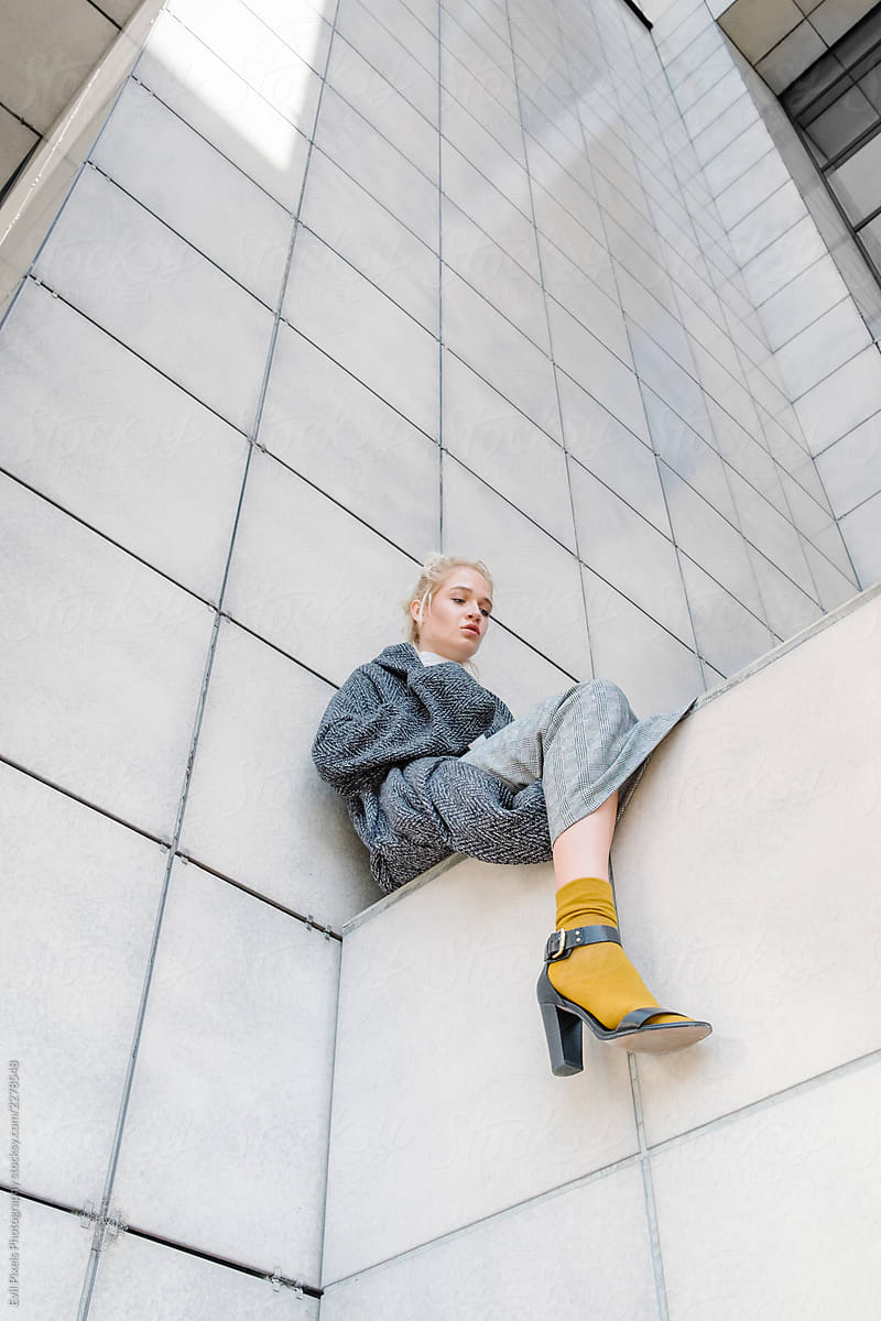 Young Trendy Woman Sitting On The Edge Of A Building