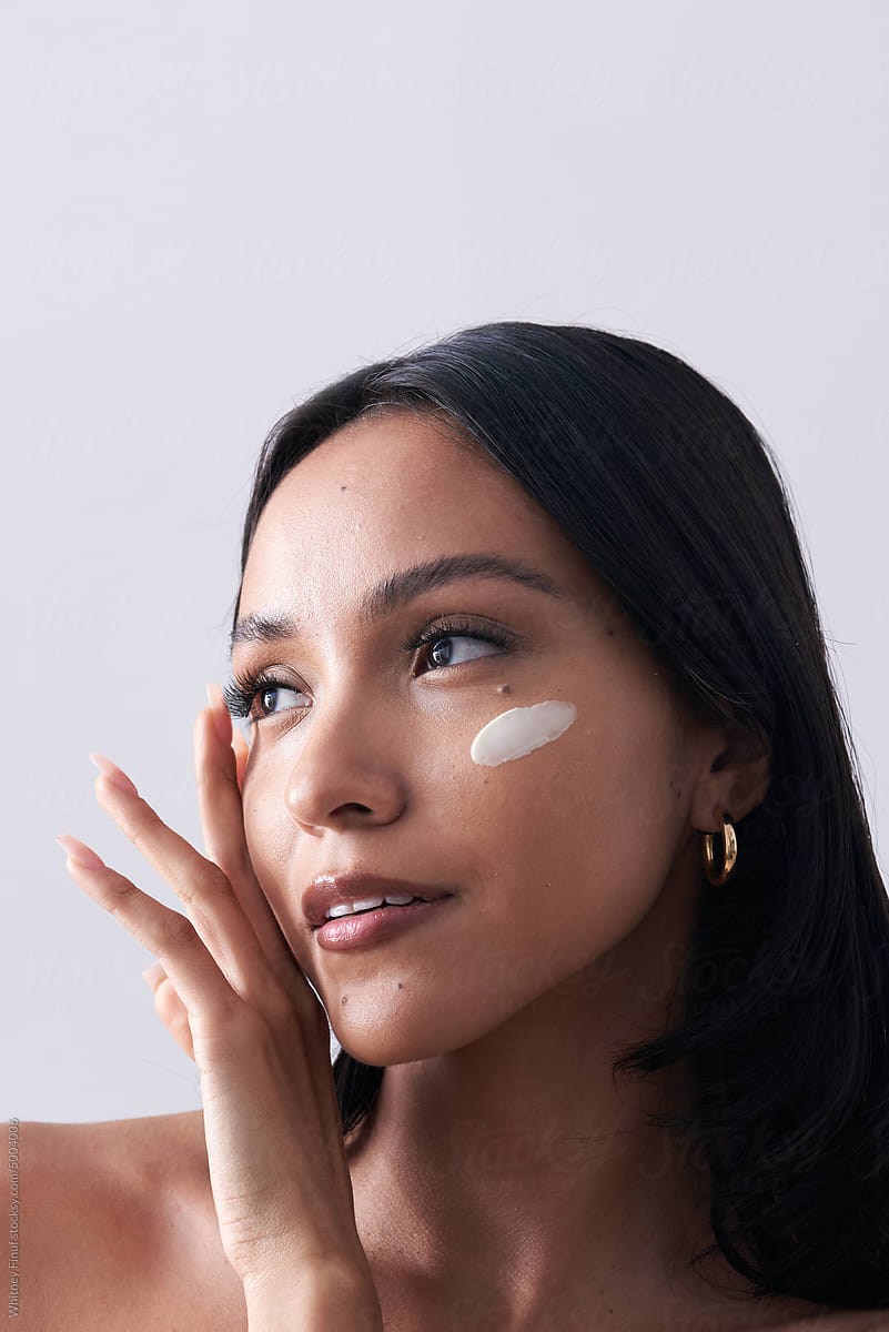 Latina Woman with Creamy Moisturizer Swatch on her Cheekbone