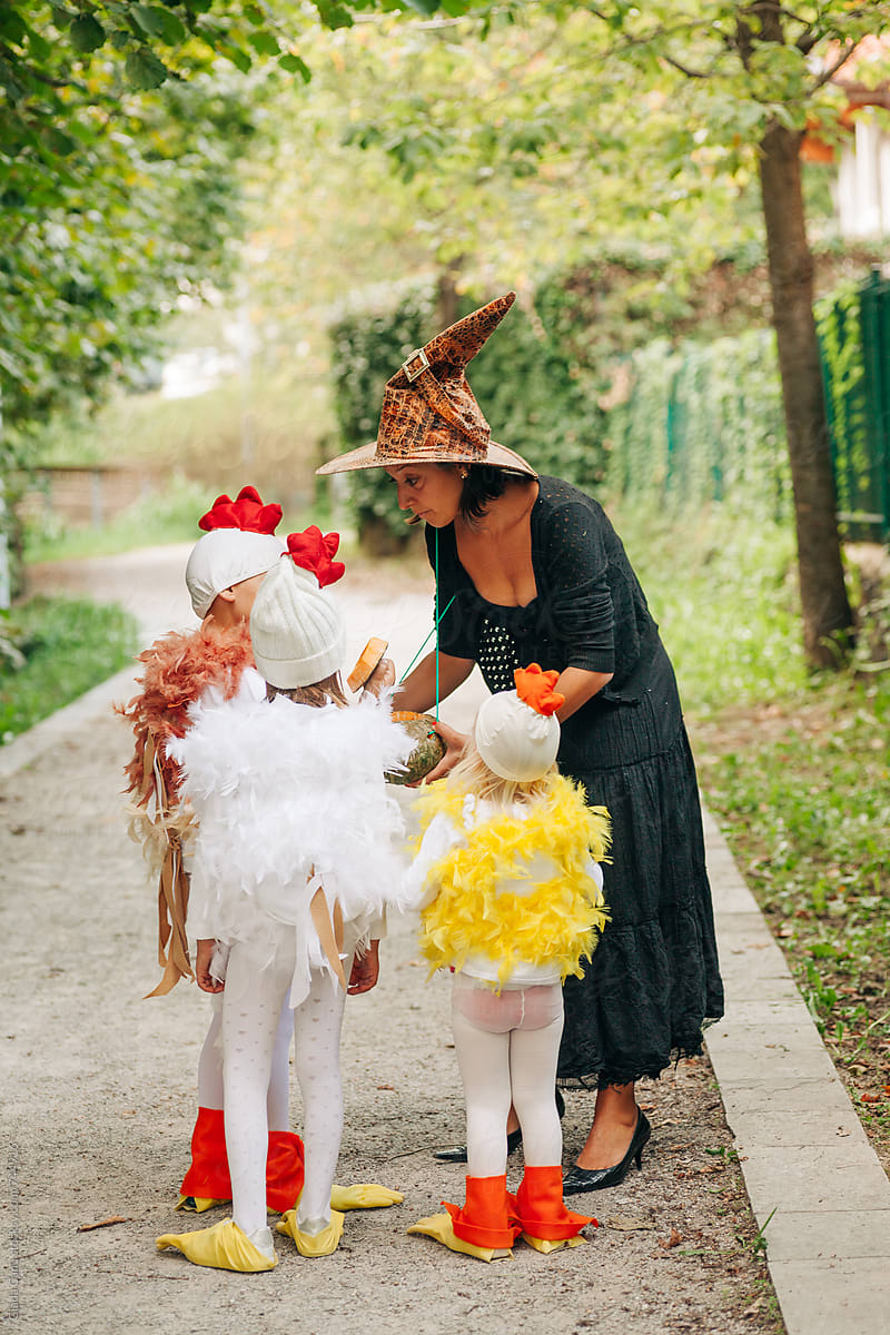 Kids in costume getting candies from a witch