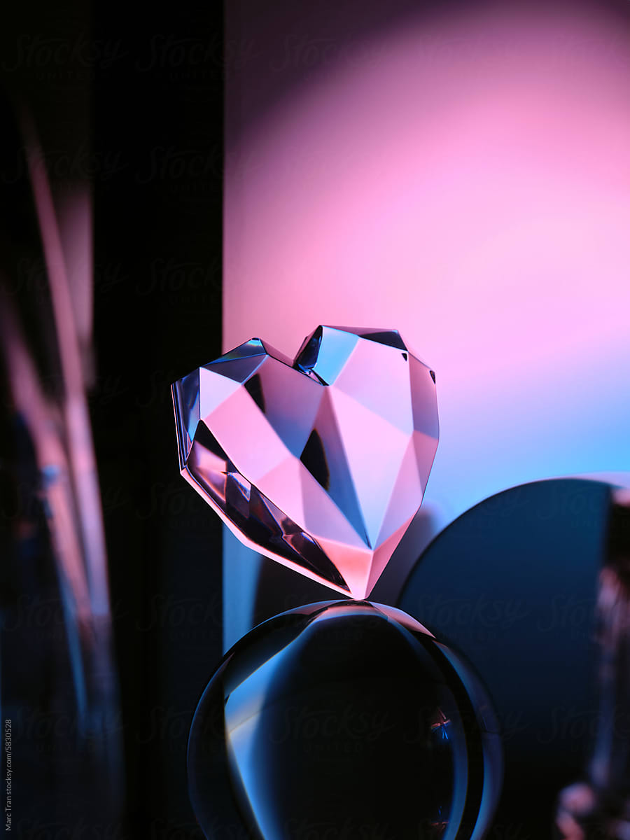 Crystal heart on podium with multicolor neon light background
